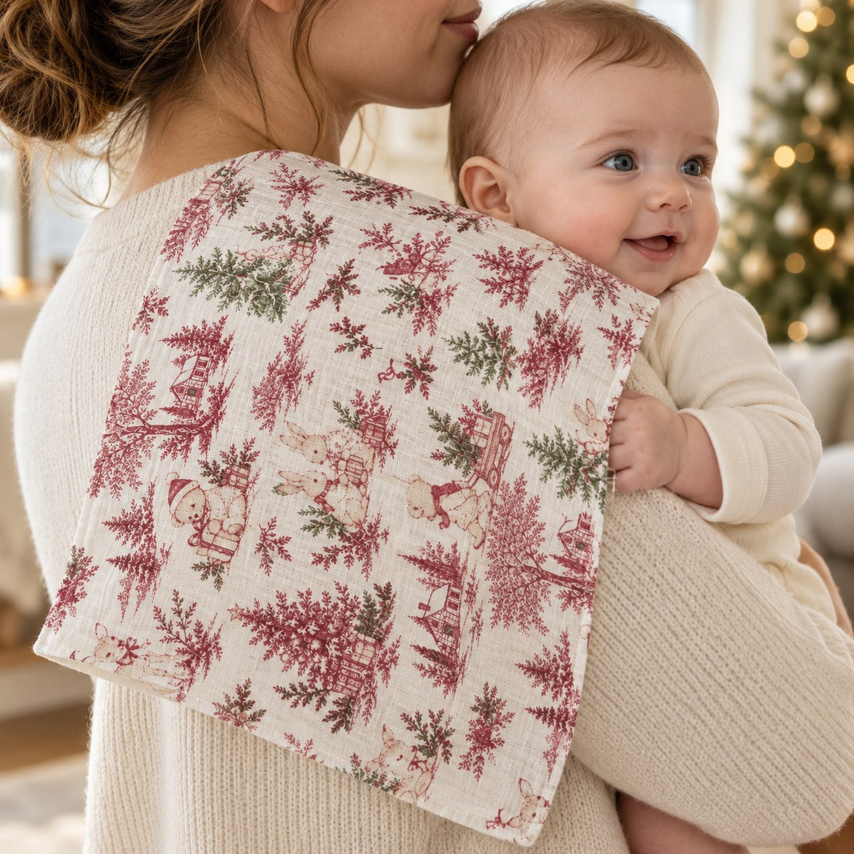 Lange motif Noël porté sur l’épaule d’une maman avec son bébé, mise en situation